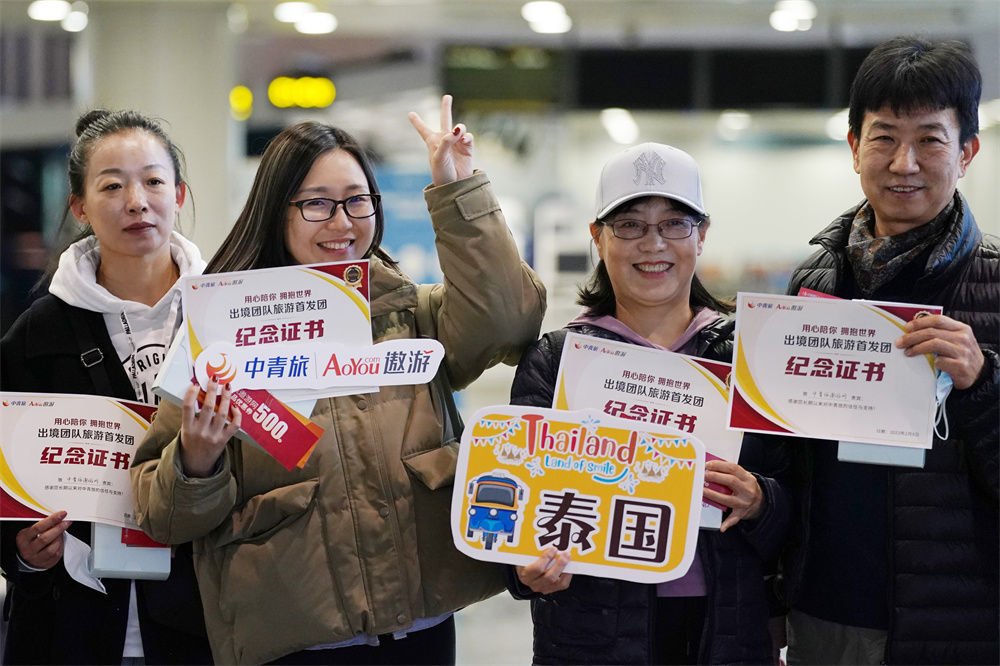 2023年2月8日,在北京首都国际机场2号航站楼,出发前往泰国旅游的游客在机场合影留念。新华社记者 鞠焕宗 摄